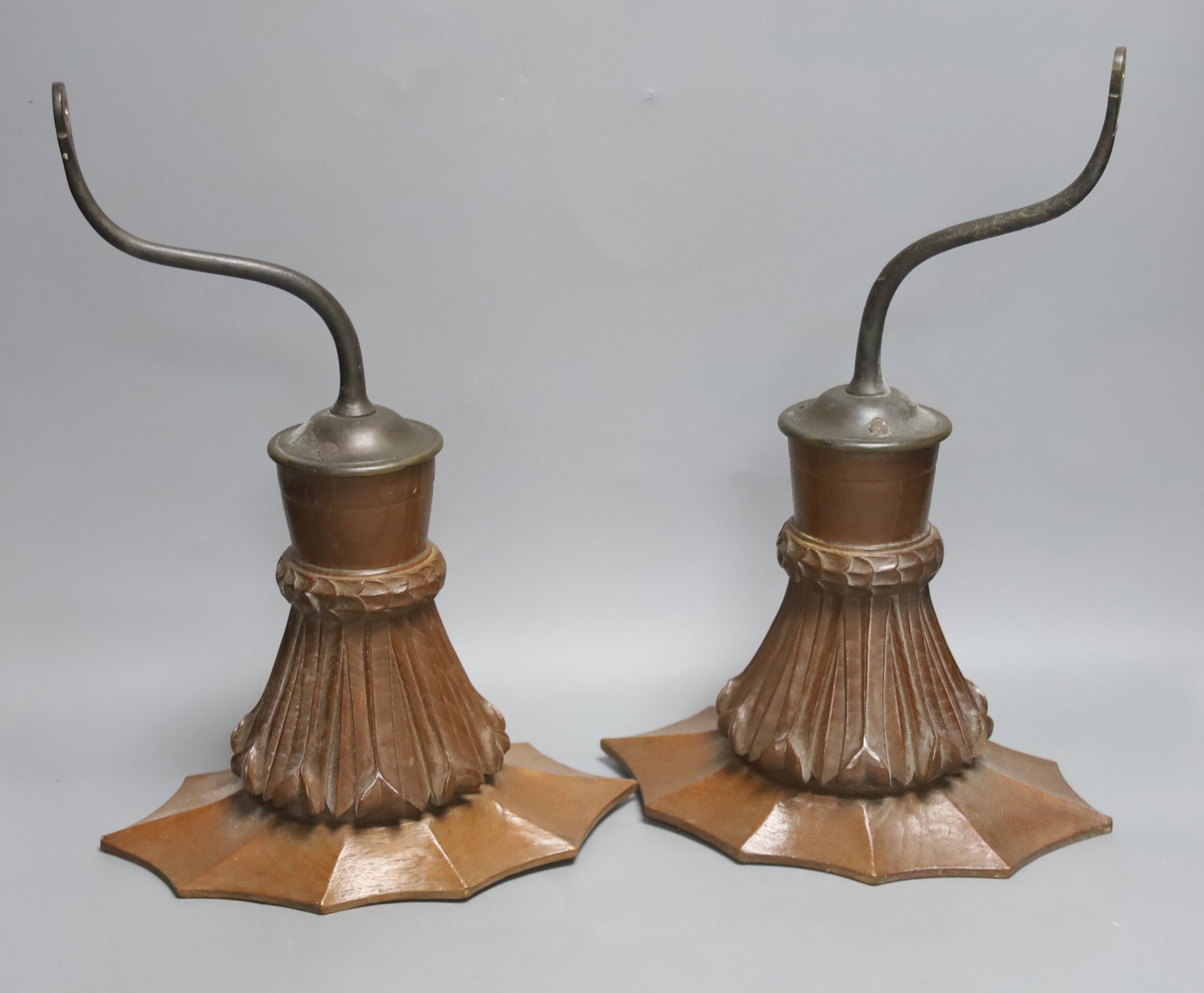 A pair of early 20th century decorative carved oand brass wall lights with glass storm shades
